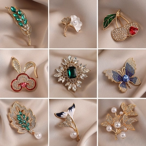 Exquisite assortment of alloy brooches with pearls and crystals on champagne silk background