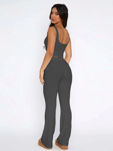 Rear view of women's dark gray sleeveless crop top and high-waisted flared trousers set