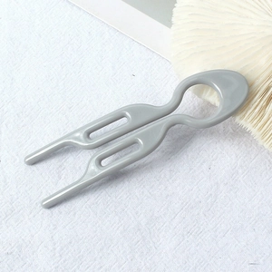 Close-up of a minimalist U-shaped hair fork with a glossy grey hollow wave design