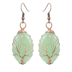 Detail of handmade bronze wire-wrapped tree of life earrings with light green stones