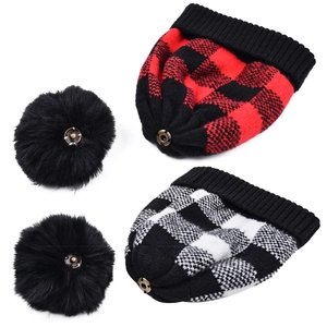 Détail de bonnets en tricot à carreaux rouges et blancs avec pompons amovibles