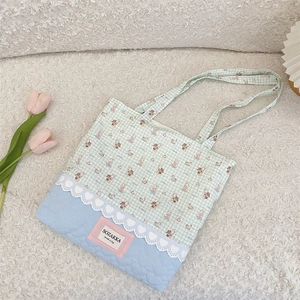 Close-up of heart quilted fabric and lace details on a cartoon canvas tote bag