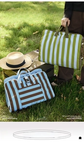 Detail of striped canvas travel organizer bag with sturdy handles and side buckles
