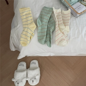 Detailed view of Morandi color striped cotton socks paired with cozy plush slippers