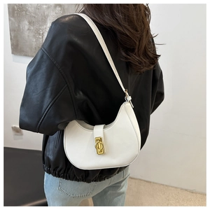 Detail view of a white crescent shoulder bag with elegant gold metal buckle hardware