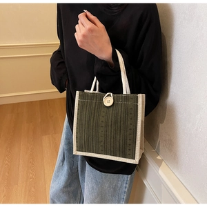 Close-up of olive green corduroy tote bag featuring cream canvas trim and cotton rope handles