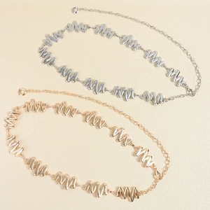 Detailed view of silver and gold wavy metal chain belts with lobster clasps and extenders
