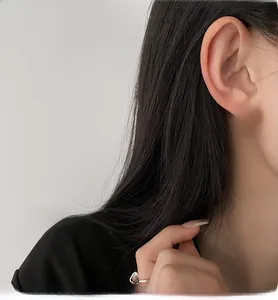 Close-up of a model wearing sweet pink heart stud earrings with elegant silver borders