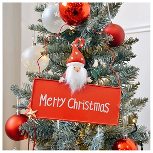 Close-up of Merry Christmas metal plaque with Santa Claus hanging on a festive tree