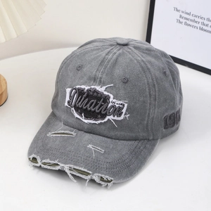 Close-up of vintage grey washed denim baseball cap with distressed details and embroidery
