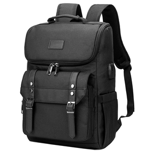 Detail of black canvas backpack showing silver metal buckle and built-in USB charging port