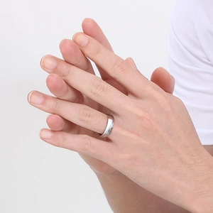 Macro detail of high-polish silver stainless steel minimalist band ring on hand