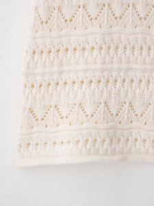 Detailed macro shot of crochet knit patterns and wavy hem on a halter mini dress