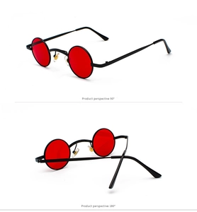 Detail view of small round steampunk sunglasses with red lenses and black metal frame