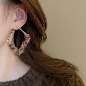 Detailed view of vintage gold hoop earrings with brown leopard print faux fur texture