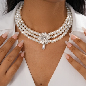 Detail of multi-layered baroque pearl necklace with sparkling rhinestone flower pendant