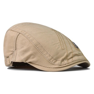 Detailed close-up of khaki cotton beret showing reinforced double stitching and metal accents