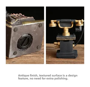 Detail of vintage resin telephone coin bank showing distressed black and gold finish and base
