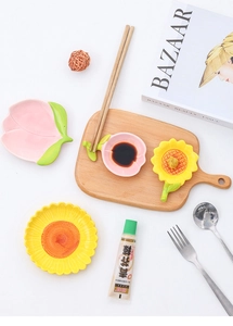 Ceramic sauce dishes in peach and sunflower shapes on a wooden board at a 45-degree angle