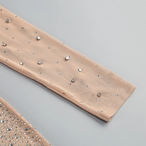 Close-up of nude mesh long sleeve with sparkling silver rhinestones and fine stitching