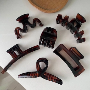 Detailed collection of six tortoiseshell claw clips in varied geometric shapes on white surface