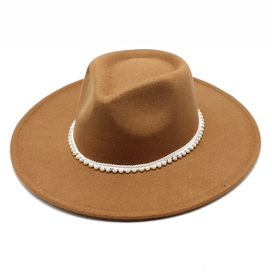 Detail of the brown wool fedora hat featuring a white pearl decorative band around the crown