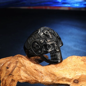 Bague tête de mort punk vintage en acier inoxydable noir sur bois naturel