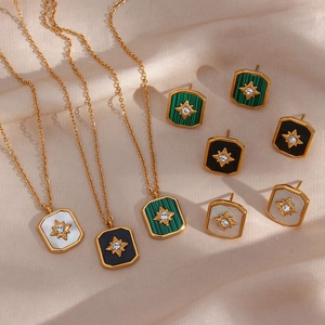 Detailed shot of vintage gold starburst necklaces and earrings on beige silk fabric