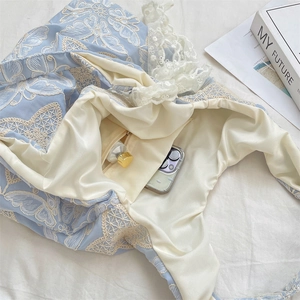 Détail du sac à broderies papillon bleues avec bordure en dentelle et poche intérieure