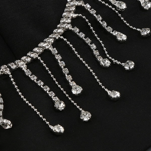 Close-up of sparkling silver fringe rhinestones with crystal beads on black fabric