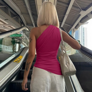 Détail du haut rose à une épaule avec texture froncée à l'arrière de cette veste ajustée