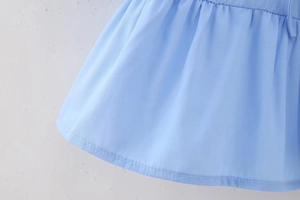 Detailansicht der Stofftextur und Saumnaht dieser hellblauen Bluse mit Puffärmeln