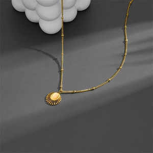 Gold sunburst pendant necklace with oval gemstone inlay on a beaded stainless steel chain