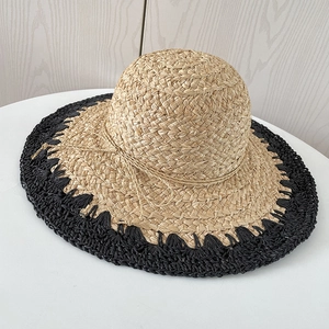 Détail du chapeau de soleil en raphia fait main avec surpiqûres noires sur le bord