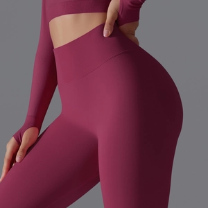 Detail of high-waist plum yoga leggings and long sleeve top with thumbhole design