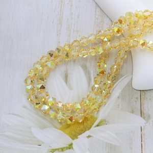Macro shot of 6mm yellow faceted crystal glass beads with AB coating on rustic wood