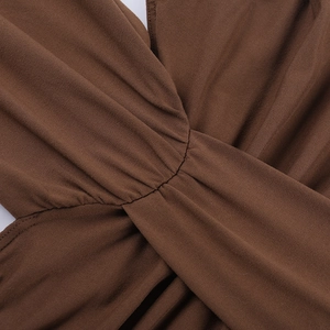 Détail du tissu crêpe caramel avec nœud et plis texturés sur la robe dos nu