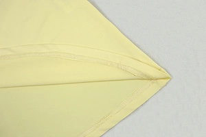Close-up of double-needle stitching and fabric texture on a pale yellow sleeveless dress