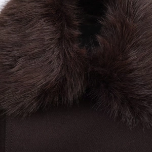 Gros plan du col en fausse fourrure moelleuse et du tissu en laine du manteau marron
