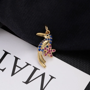 Close-up of gold hummingbird pendant with blue pink zircons and star-shaped flower