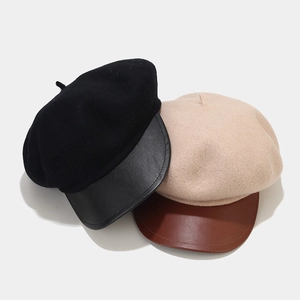Flat lay of wool blend newsboy hats with leather brims in black and beige tones