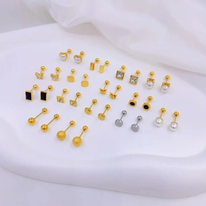 Detailed close-up of mixed gold stud earrings on premium white silk background fabric
