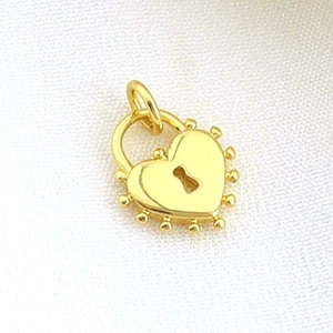 Macro view of a gold-toned heart padlock pendant featuring beaded edges and a keyhole detail