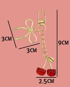 Vue détaillée montrant les dimensions du porte-clés cerise rouge avec nœud doré chic
