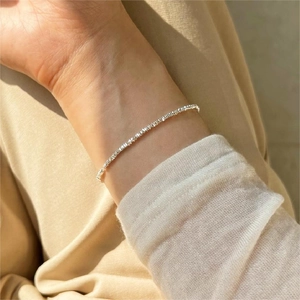 Detailed macro shot of a delicate S925 sterling silver beaded bracelet on a woman wrist