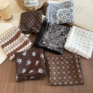 Collection of retro floral and polka dot silk scarves on a rustic wooden table setup