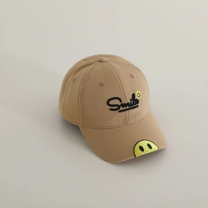 Detail shot of khaki cotton baseball cap with embroidered yellow smile and Smile text
