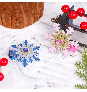Detail of snowflake hair clips with blue and pink rhinestones on a rustic winter background