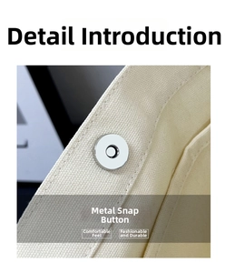 Close-up of the durable silver magnetic hardware buckle on the off-white canvas tote bag