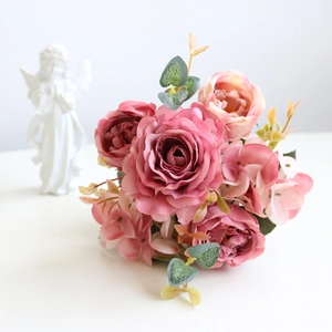 Detail of faux silk hydrangea peony bouquet with pink and purple roses and eucalyptus